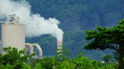 Factory chimney in the middle of the forest Stock Photos