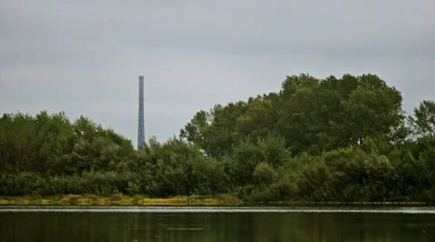 Factory chimney over the river Stock Footage 12528956
