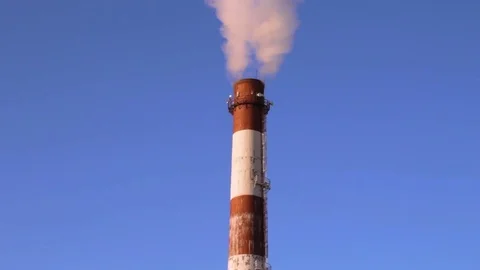 Factory chimney pipe with smoke at blue sky background Stock Footage 73483860