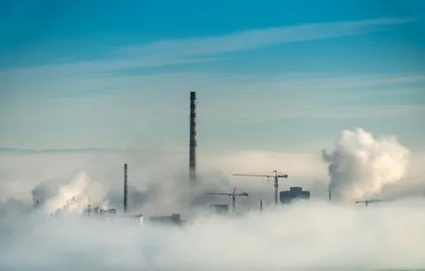 Factory chimneys and clouds of steam Stock Photos