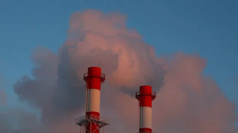 Factory chimneys with fast moving dense smoke at dawn, beautiful warm light Stock Footage 34276374