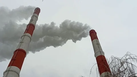 Factory chimneys release smoke into the atmosphere and pollute the environment . Stock Footage 120742794