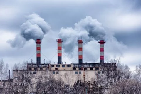 Factory chimneys from which there is dense gray smoke Stock Photos