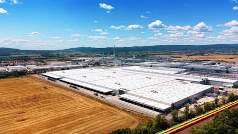 Factory complex beside harvested field and freight train Stock Footage 340556642