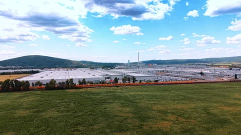 Factory complex beyond green field and railway Stock Footage 340558392