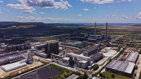 Factory complex located in a rural area with mountains in the background Stock Footage 339649254