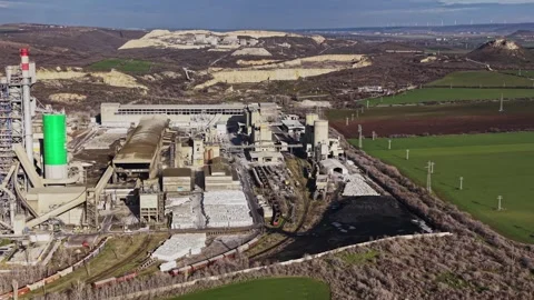Factory complex in a rural area with fields and hills in the background Video stock 336546318