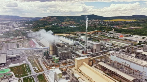 Factory complex in a rural area with smoke rising into the sky during daytime Stock Footage 341129411