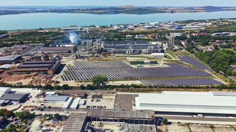 Factory complex with solar panels and water body in the background during Stock Footage 342334647