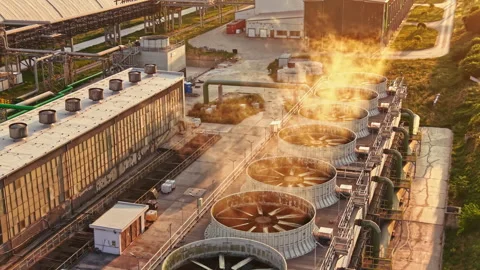 Factory cooling towers release steam in the early evening at an industrial site Stock Footage 340945852