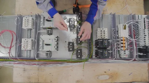 Factory electrical cabinet assembly using a hand screwdriver in factory Stock Footage