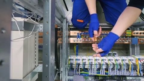 Factory electrician engineer installing cables with screwdriver, tighten the nut Stock Footage 73617564