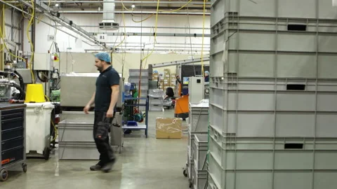 Factory employee walks around the workshop and picks up a hammer Stock Footage 276358134
