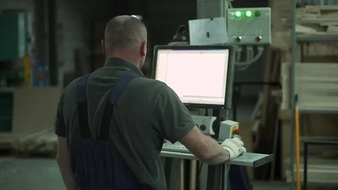 The factory employee works at the computer, assigns tasks. prepares to work Stock Footage 84043545