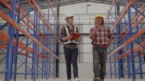 Factory engineer and staff checking goods on shelves in warehouse.  Stock Footage 159533385