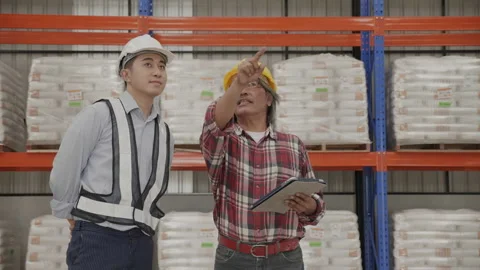 Factory engineer and staff checking goods on shelves in warehouse. Stock Footage 159536489