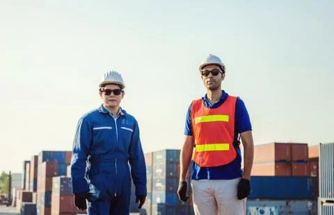 Factory engineer and worker man in hard hat smiling and looking at sky with joy Фото