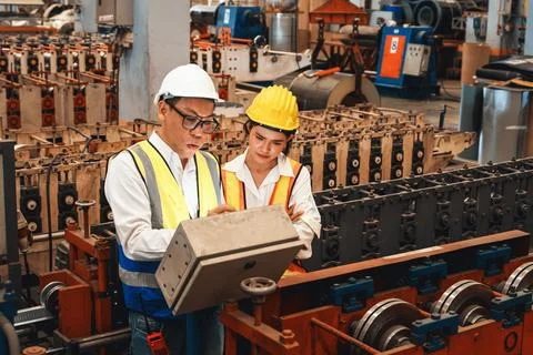 Factory engineer with assistant using laptop inspect factory. Exemplifying Stock Photos