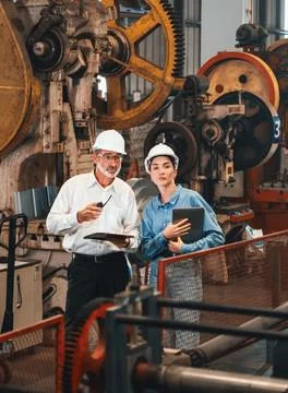 Factory engineer with assistant using laptop inspect factory. Exemplifying Stock Photos