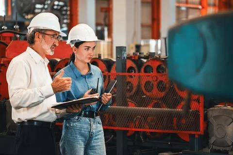 Factory engineer with assistant using laptop inspect factory. Exemplifying Stock Photos