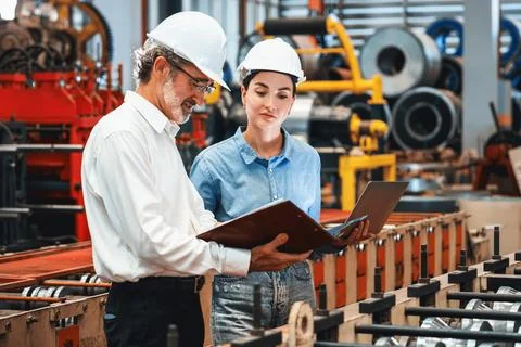 Factory engineer with assistant using laptop inspect factory. Exemplifying Stock Photos
