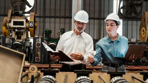 Factory engineer with assistant using laptop inspect factory. Exemplifying Stock Photos