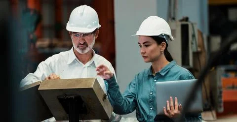 Factory engineer with assistant using laptop inspect factory. Pano Exemplifying Stock Photos