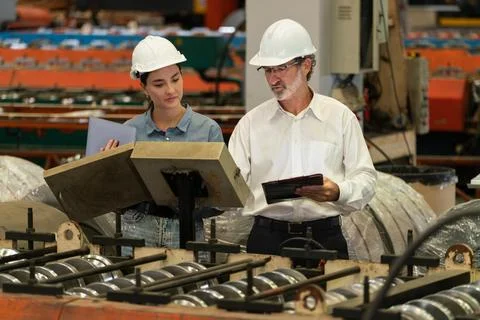 Factory engineer with assistant using laptop inspect factory. Exemplifying Stock Photos