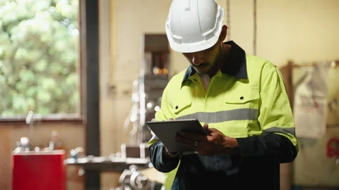 Factory engineer is checking the list to inspect the factory machinery Stock Footage 255811416