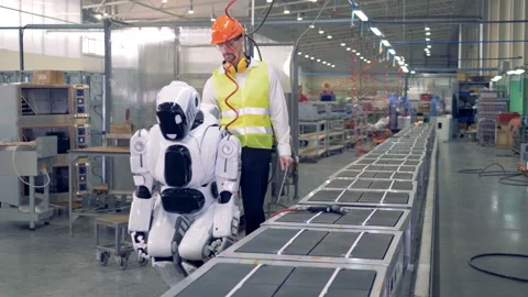 Factory engineer controls a robot, while it works with a tool. 4K. Video stock 88991268
