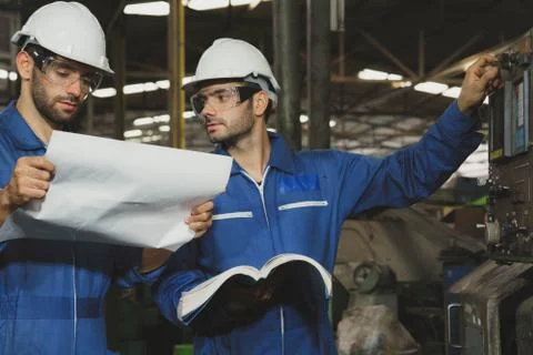 Factory Engineer or mechanical worker   checking on production in a factory. Stock Photos