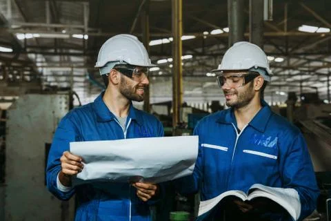 Factory Engineer or mechanical worker checking on production in a factory. Stock Photos