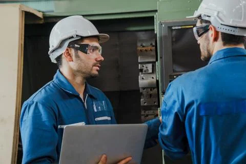 Factory Engineer or mechanical worker checking on production in a factory. Stock Photos