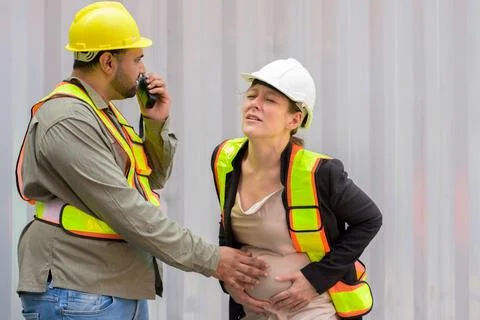 Factory engineer or worker man helping pregnant businesswoman Stock Photos