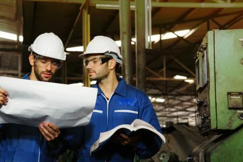 Factory Engineer serios talking about work on production in a factory. Stock Photos