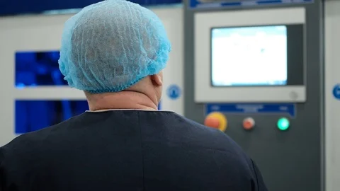 Factory engineer in a special headdress controls production technology using an 스톡 동영상 121438698