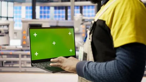 Factory engineer using green screen laptop to calibrate high tech machinery Stock Photos