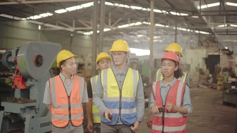 A factory engineer wearing a red helmet is introducing an industrial plant to Stock Footage 170244366