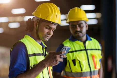 Factory engineer worker reading bad news lay off notify at smartphone serious Stock Photos