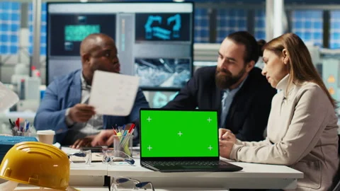 Factory engineers refining production layouts using chroma key laptop Stock Footage 306099622