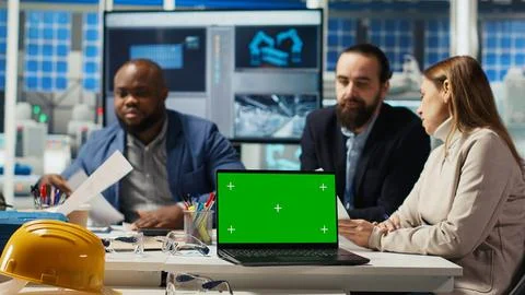 Factory engineers refining production layouts using chroma key laptop Stock Photos