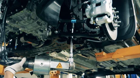 Factory facility interior, industrial equipment. Car mechanic assembling a car 動画素材 140979344