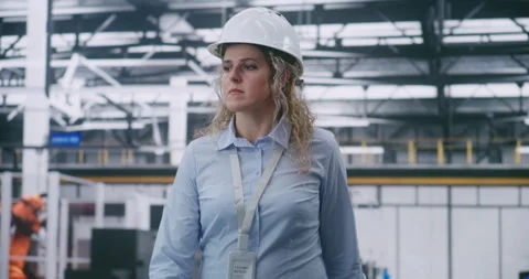 Factory Floor Management, Female Engineer Wearing White Hard Hat and Checking Video stock 325733599