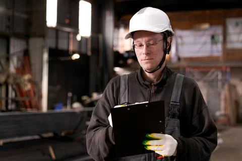 Factory Inspector Reading Documents at Metal Storage Stock Photos