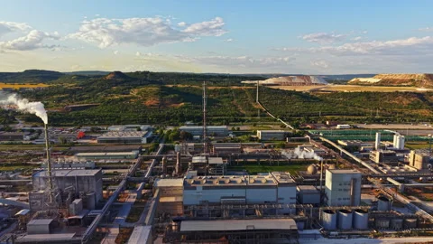 Factory located in a green area with hills in the background and clouds in the Stock Footage 340962139