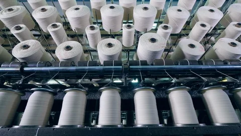 Factory machines spin bobbins, coiling white threads. Stock Footage 115704579