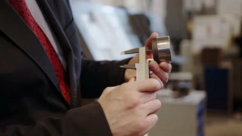 At the factory: A male engineer checks the workmanship of a part with a caliper. Stock Footage 152508978