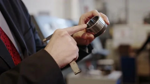 At the factory: A male engineer checks the workmanship of a part with a caliper. Stock Footage 152508987