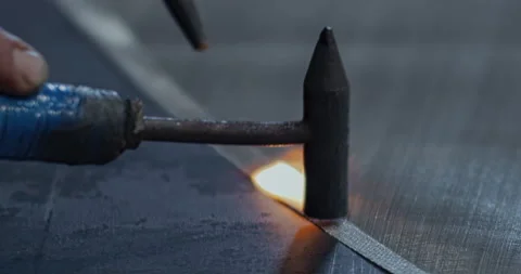 Factory Man Works With Small Hammer and Uses Fire From Blow Torch to Solder Stockbeeldmateriaal 172542412