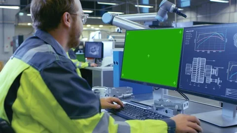 At the Factory: Mechanical Engineer Works on the Green Mock-up Screen Computer Video stock 93688706
